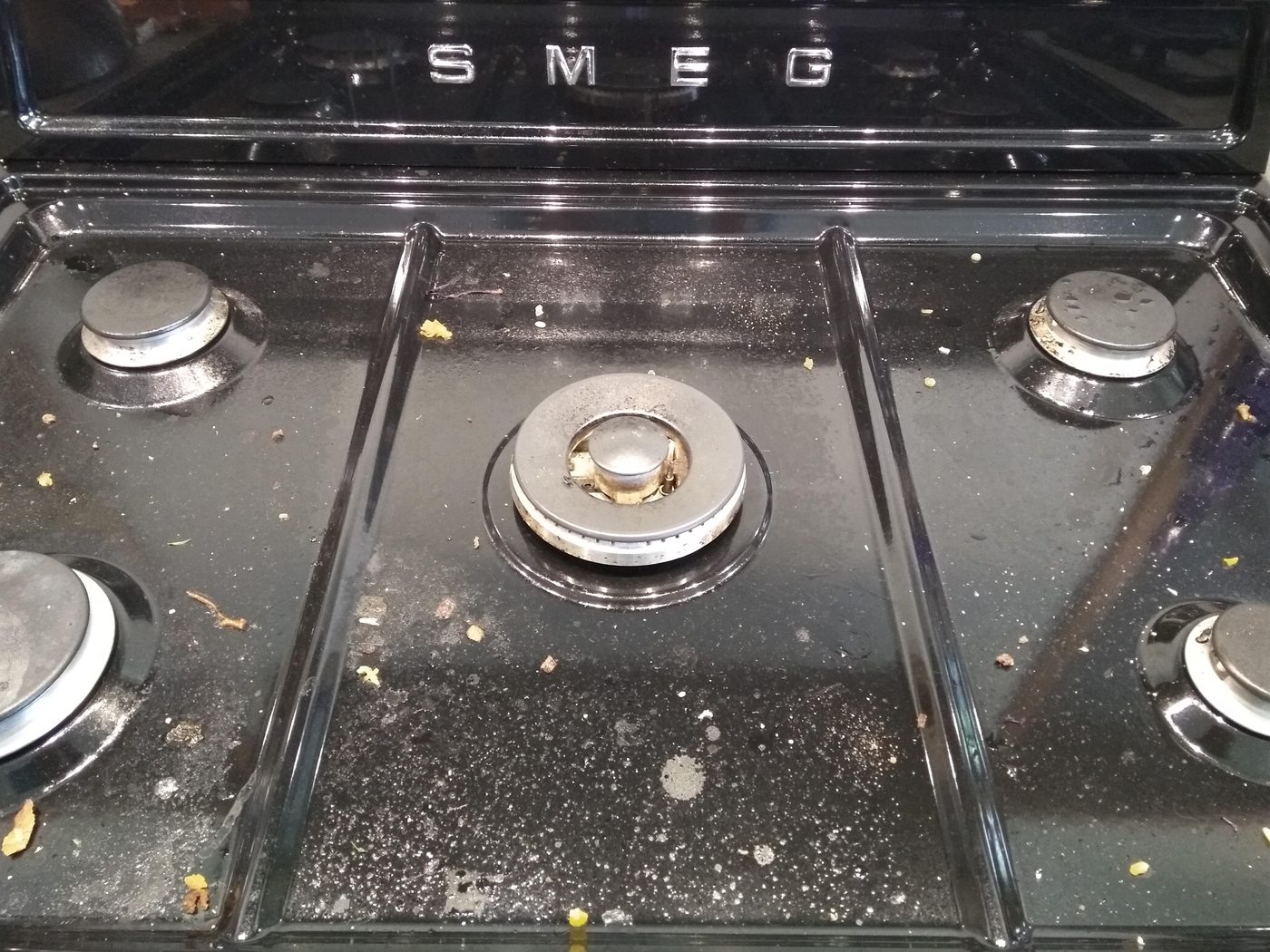 Grease-spattered Smeg stove top before cleaning